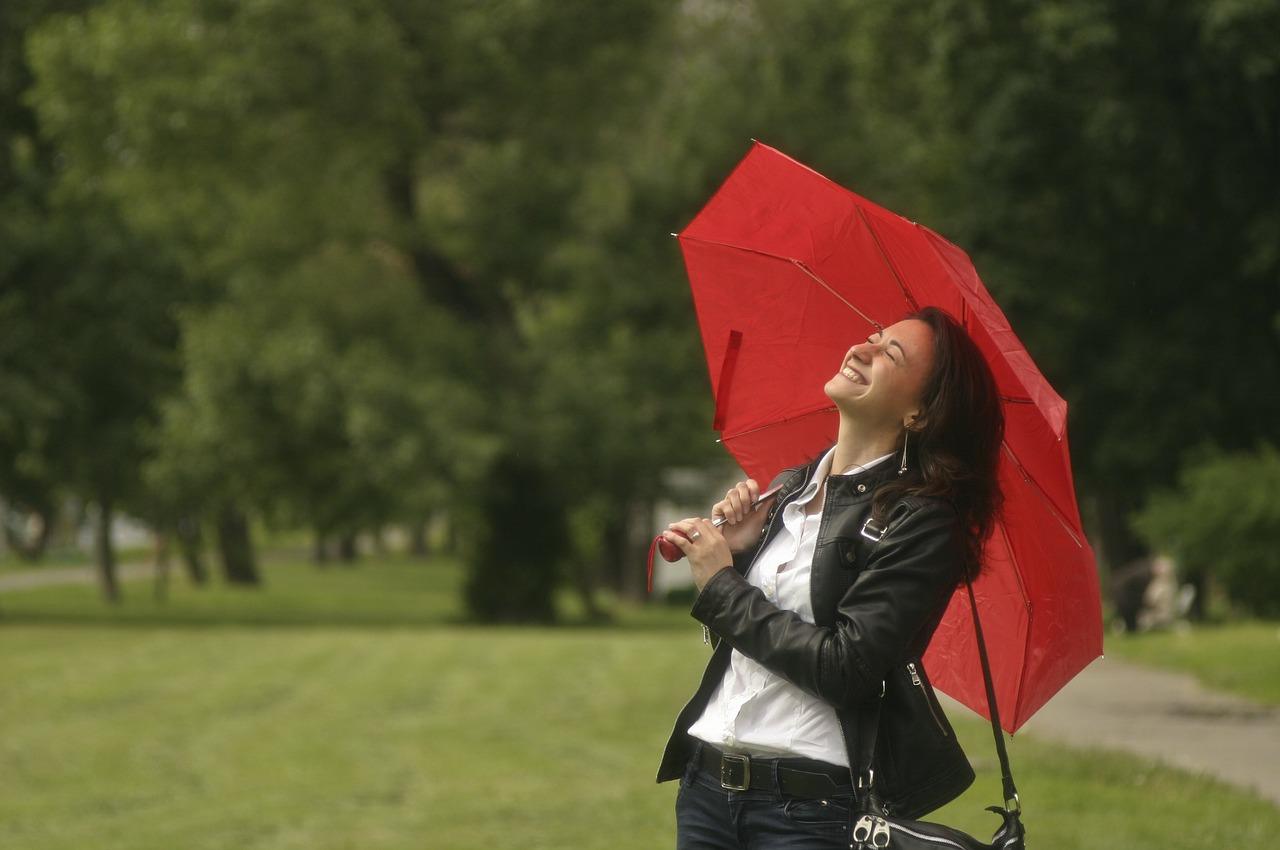 Foto av glad jente med paraply