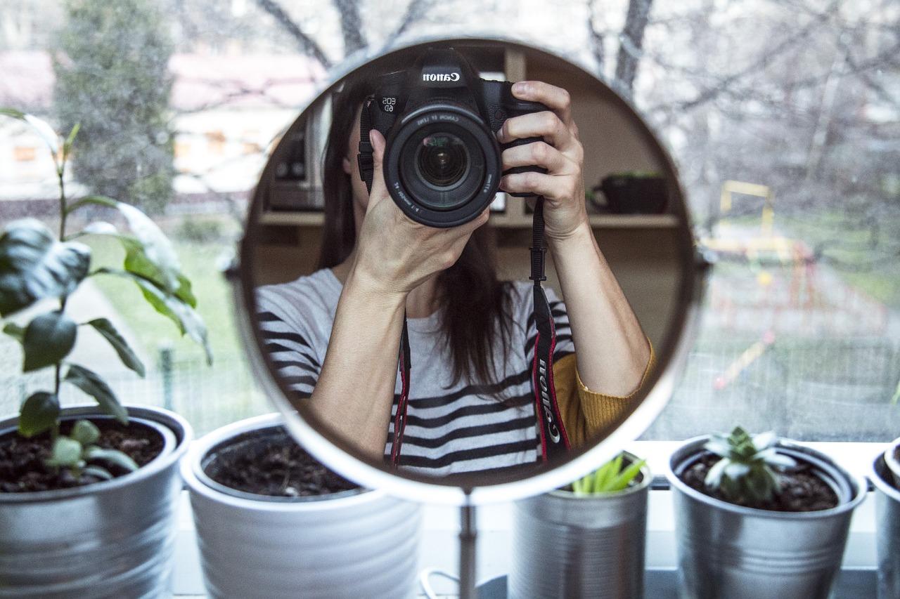 Pige fotograferer sig selv gennem et spejl