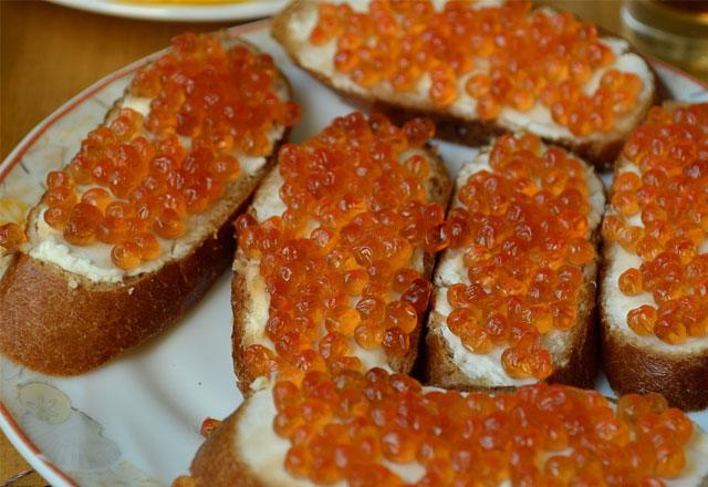 Sandwich with pink salmon caviar and butter on white bread